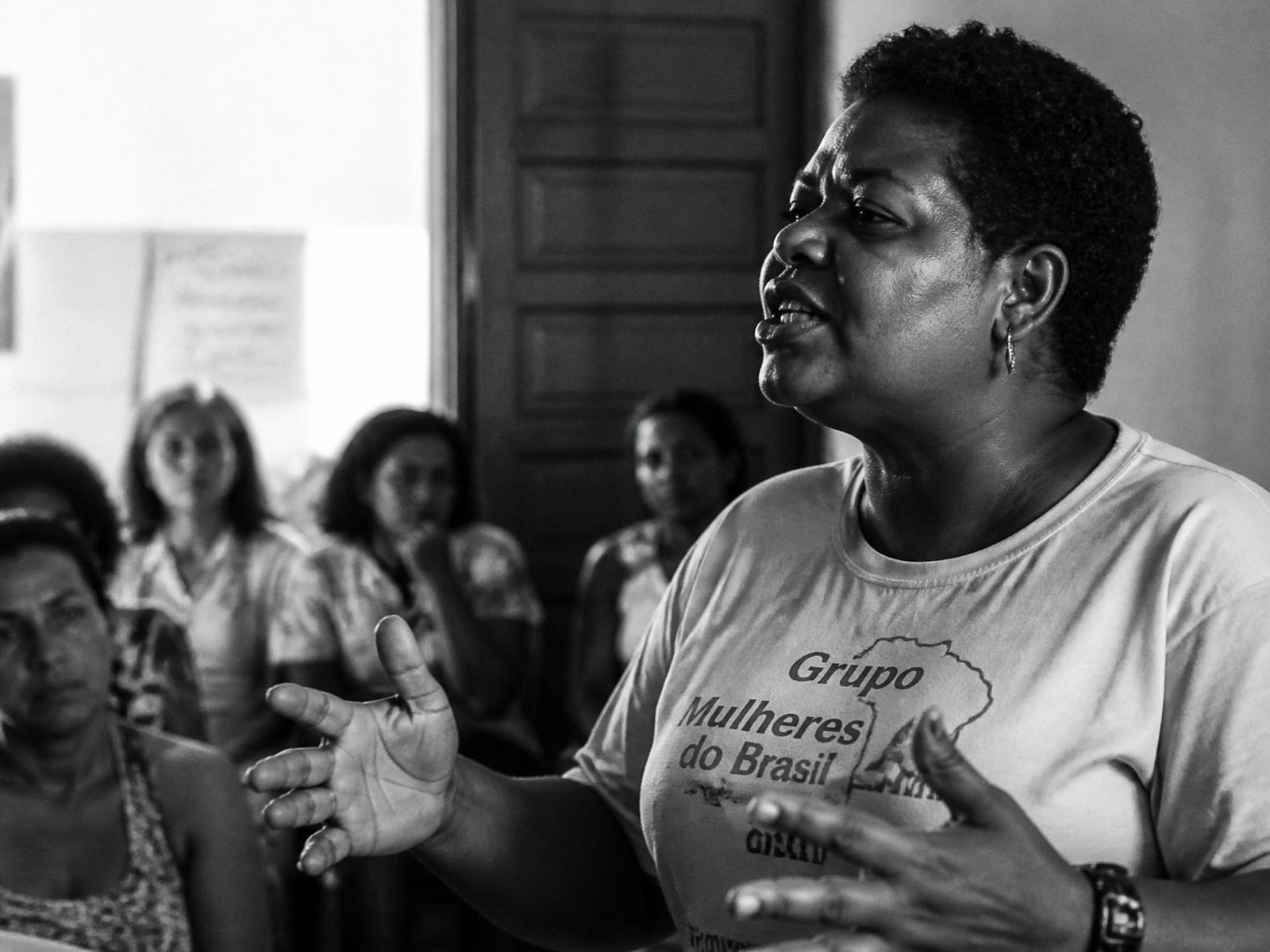 Mulher discursando em reunião comunitária
